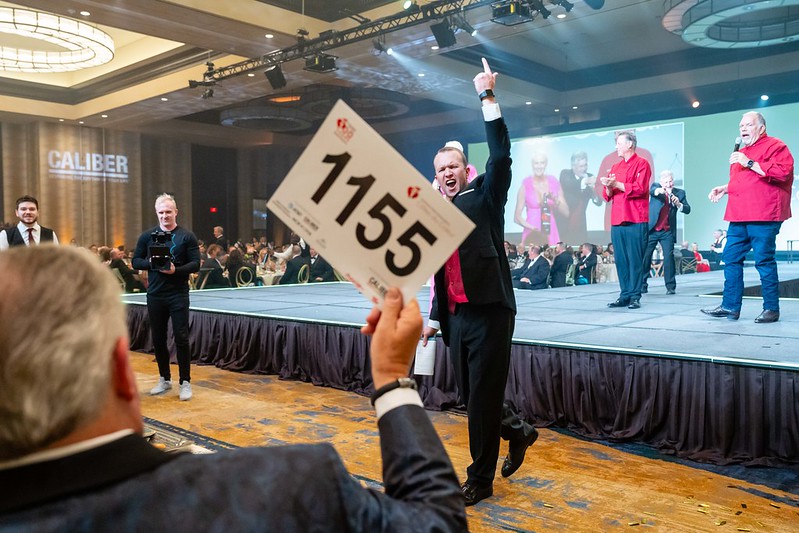 Attendee holding up bidder paddle